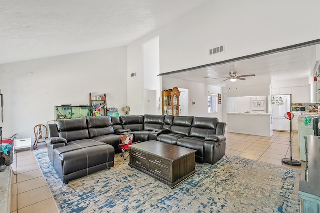 living room with a textured ceiling, light tile patterned flooring, and ceiling fan