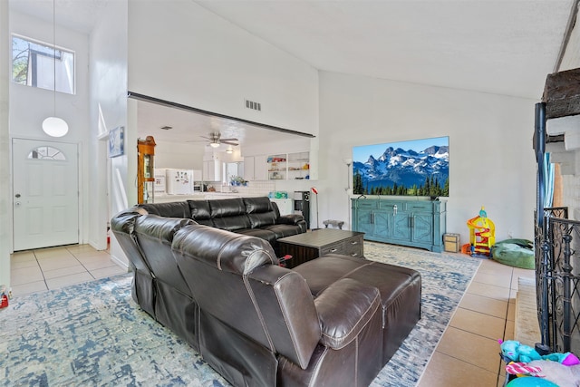 tiled living room featuring high vaulted ceiling and ceiling fan