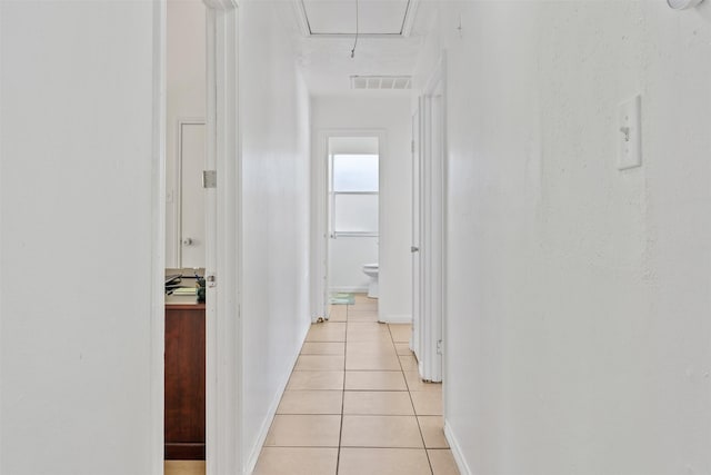1603 Cantrell Blvd, Conroe, TX 77301 - hallway with attic access, light tile patterned flooring, and baseboards