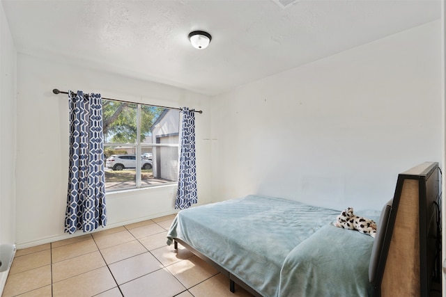 tiled bedroom with a textured ceiling