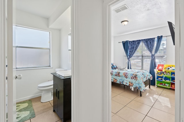 bedroom featuring a textured ceiling and light tile patterned floors