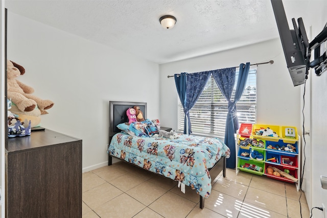 bedroom featuring a textured ceiling and light tile patterned floors