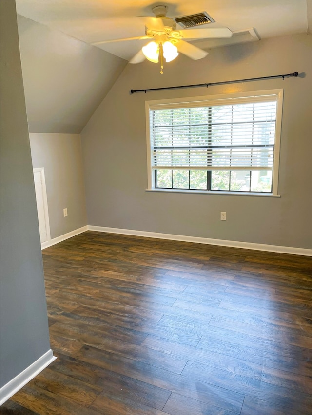 additional living space featuring dark hardwood / wood-style flooring, vaulted ceiling, and plenty of natural light