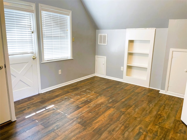 additional living space featuring dark wood-type flooring, vaulted ceiling, and built in shelves