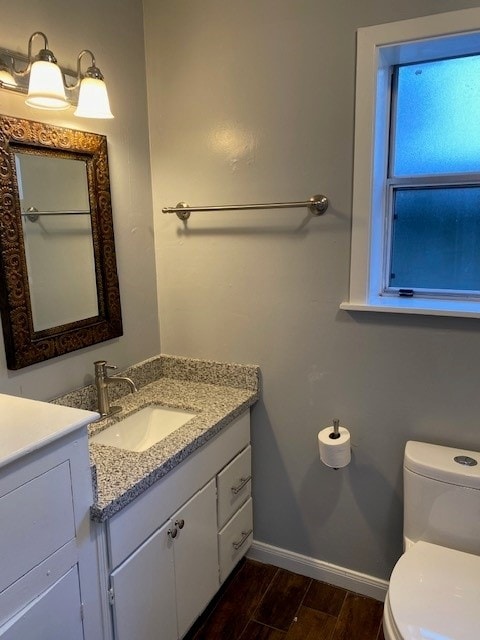 bathroom featuring vanity, toilet, and hardwood / wood-style floors