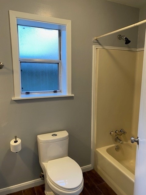 bathroom featuring hardwood / wood-style floors, shower / bathing tub combination, and toilet