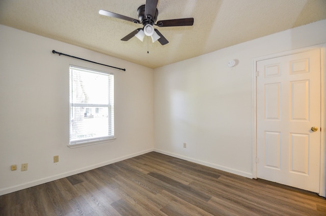 empty room featuring ceiling fan, a textured ceiling, and dark hardwood / wood-style flooring