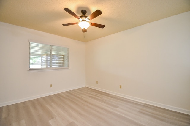 unfurnished room with ceiling fan, a textured ceiling, and light wood-type flooring