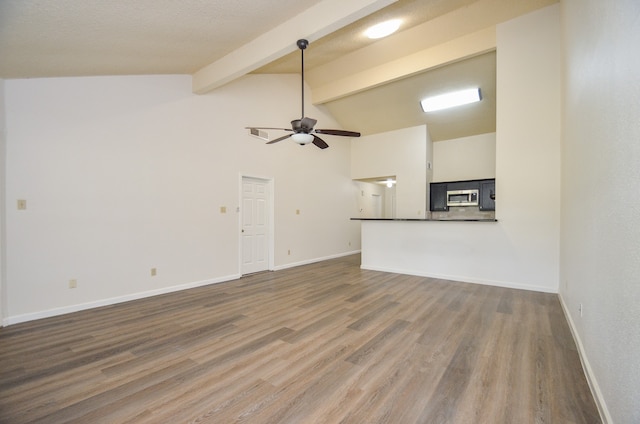 unfurnished living room featuring beam ceiling, a textured ceiling, wood-type flooring, and ceiling fan