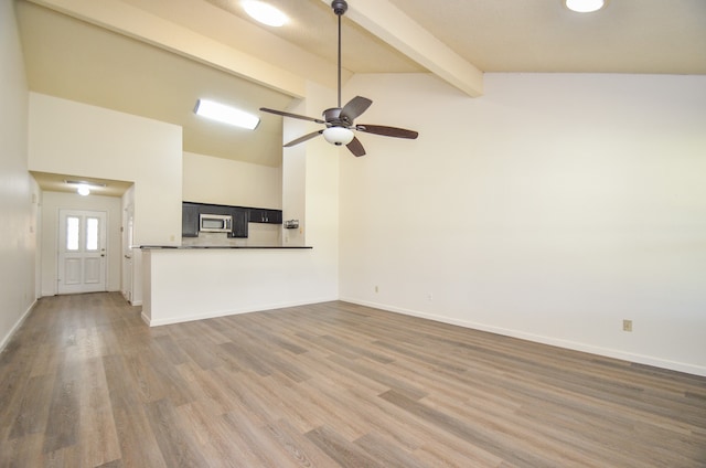 unfurnished living room featuring beam ceiling, hardwood / wood-style flooring, high vaulted ceiling, and ceiling fan