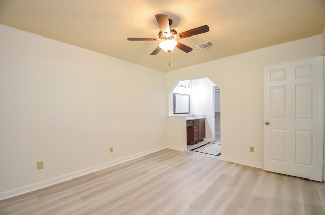 unfurnished living room featuring light hardwood / wood-style floors, a textured ceiling, and ceiling fan