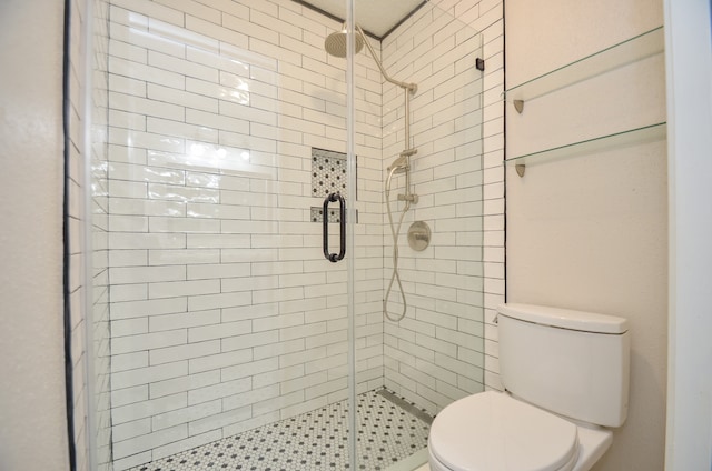 bathroom with toilet and a shower with shower door