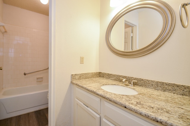 bathroom with vanity, bathtub / shower combination, a textured ceiling, and hardwood / wood-style floors