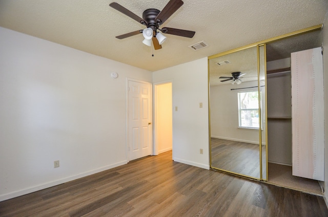 unfurnished bedroom featuring a closet, hardwood / wood-style floors, a textured ceiling, and ceiling fan