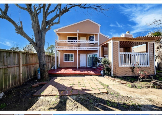 rear view of property featuring a deck, a patio area, and a balcony