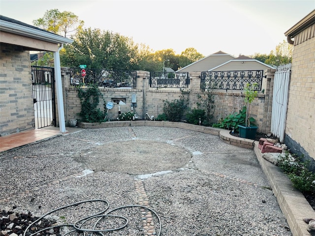 view of yard featuring a gate, fence, and a patio area