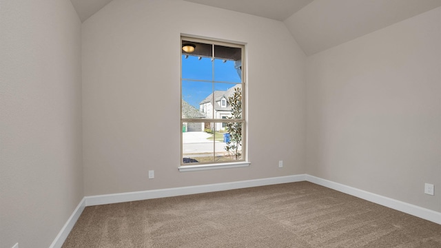 unfurnished room with lofted ceiling, carpet floors, and baseboards