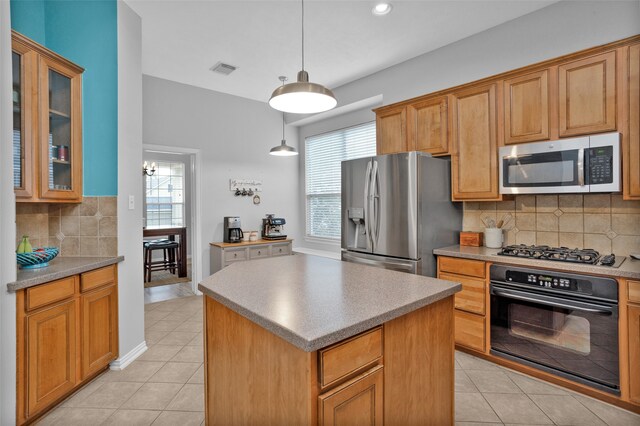 kitchen featuring a center island, stainless steel appliances, tasteful backsplash, and light tile patterned floors