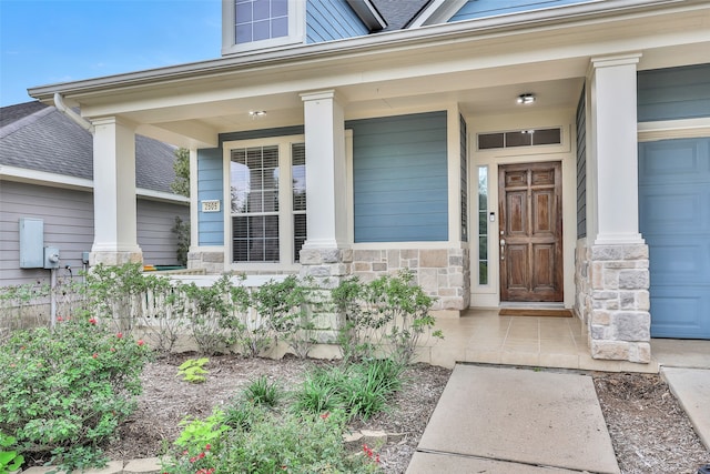 entrance to property with covered porch and a garage