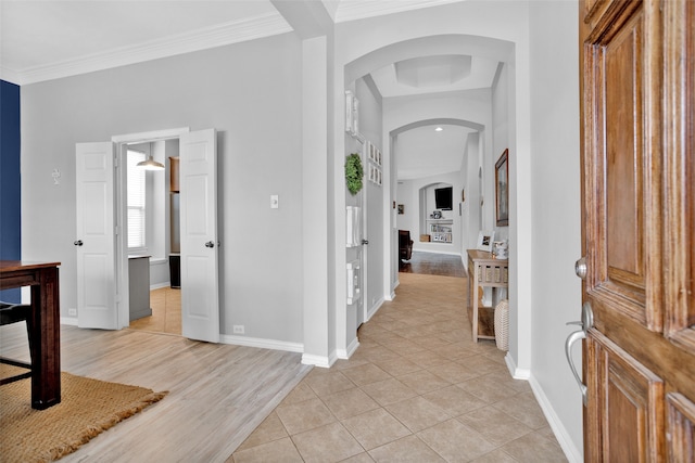 foyer with light hardwood / wood-style floors and crown molding