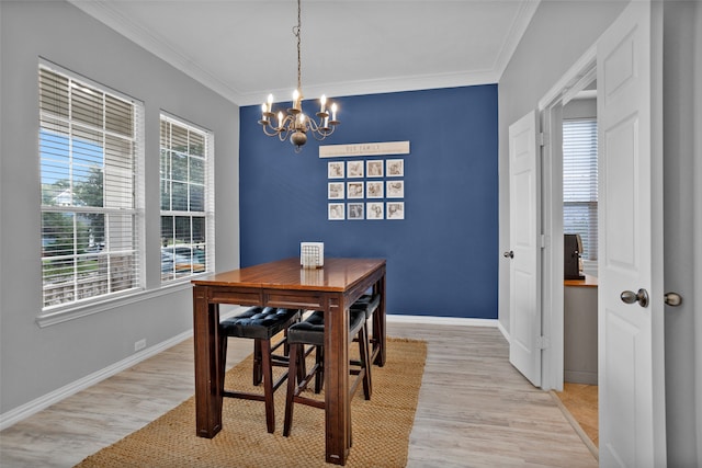 dining area with crown molding, a notable chandelier, and light hardwood / wood-style flooring