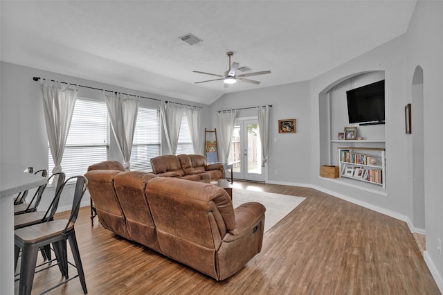 living room featuring vaulted ceiling, light hardwood / wood-style flooring, french doors, and ceiling fan