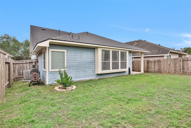 back of property featuring cooling unit and a yard