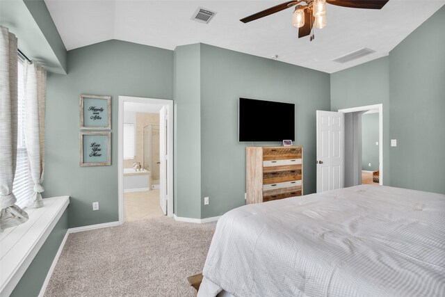 carpeted bedroom featuring multiple windows, ensuite bath, vaulted ceiling, and ceiling fan