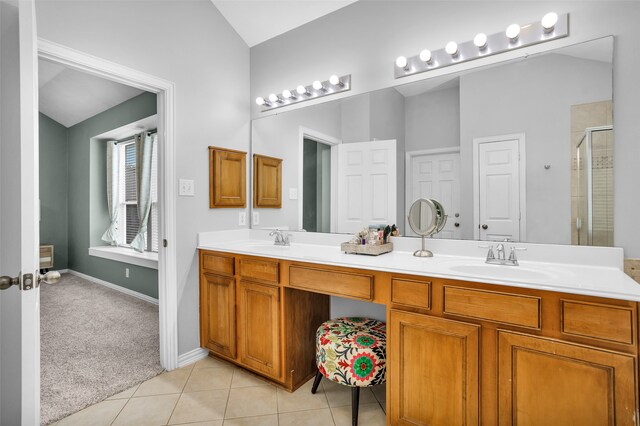 bathroom featuring vanity, lofted ceiling, tile patterned flooring, and a shower with door