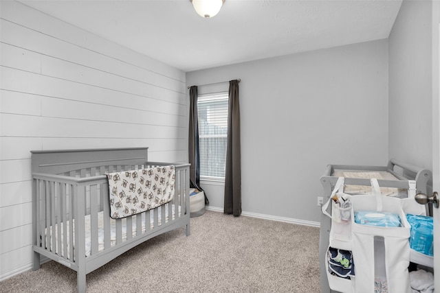 carpeted bedroom featuring a nursery area