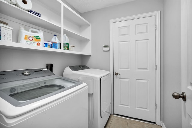 laundry area featuring washing machine and dryer and light tile patterned floors