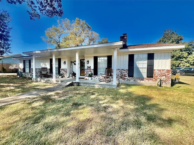 back of property featuring a yard and covered porch