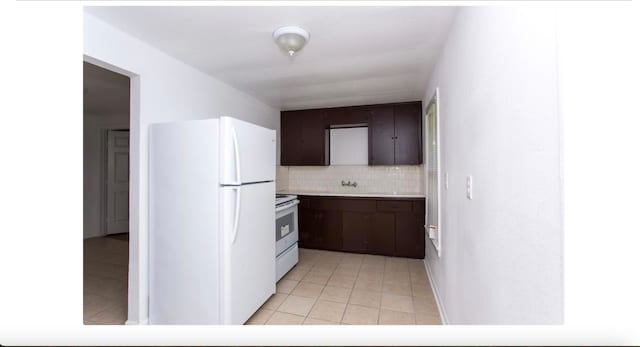 kitchen with decorative backsplash, sink, light tile patterned flooring, dark brown cabinetry, and white appliances