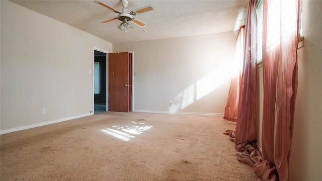 unfurnished room with ceiling fan, light carpet, and a textured ceiling