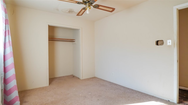 unfurnished bedroom featuring light carpet, a closet, and ceiling fan