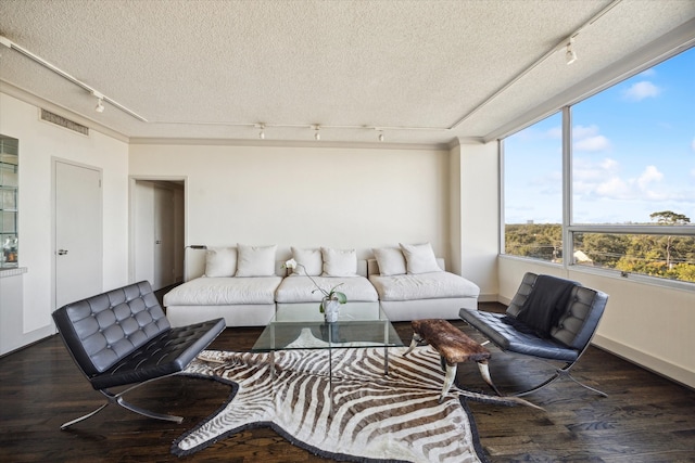 living room with track lighting, a textured ceiling, and dark wood-type flooring