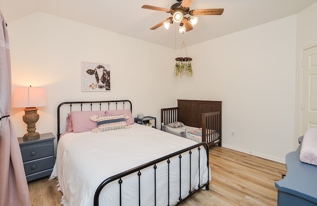 bedroom with light hardwood / wood-style floors, vaulted ceiling, and ceiling fan