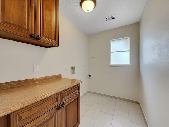 14718 W Bend Dr, Houston, TX 77082 - laundry room featuring cabinet space, hookup for an electric dryer, hookup for a washing machine, baseboards, and light tile patterned floors