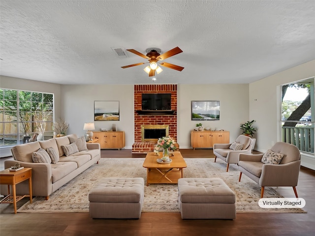 living room with a wealth of natural light, hardwood / wood-style floors, and a textured ceiling