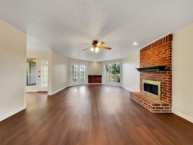 14718 W Bend Dr, Houston, TX 77082 - unfurnished living room featuring wood finished floors, ceiling fan, baseboards, a textured ceiling, and a brick fireplace