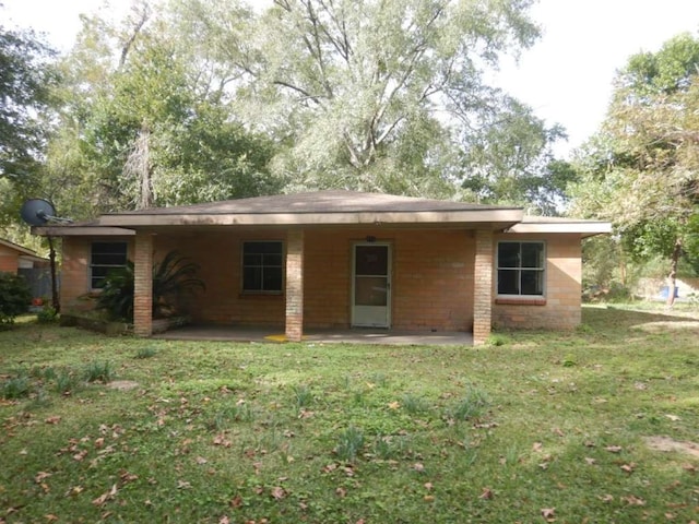 rear view of house featuring a yard and a patio area