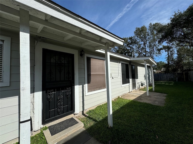 property entrance with a lawn