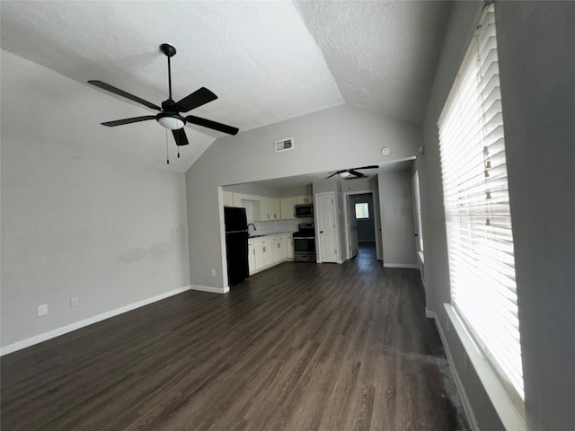 unfurnished living room with a textured ceiling, ceiling fan, dark hardwood / wood-style flooring, and vaulted ceiling