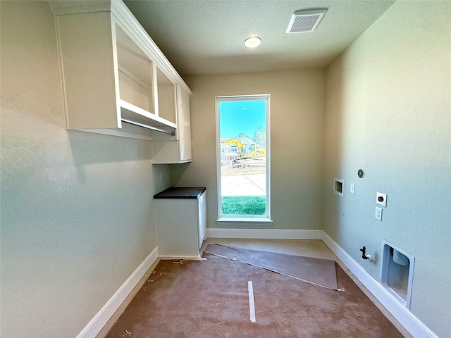 clothes washing area featuring hookup for a gas dryer, washer hookup, a textured ceiling, and hookup for an electric dryer