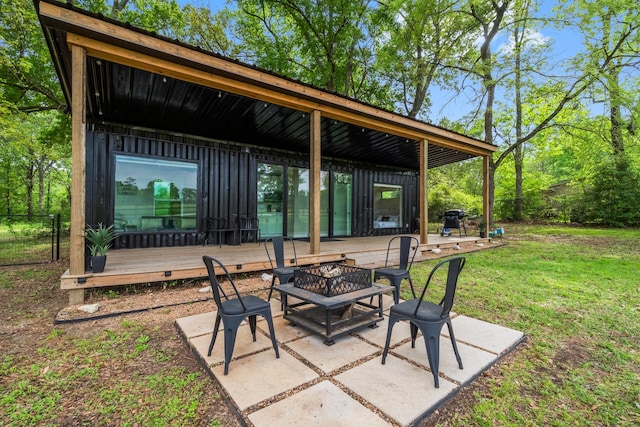 view of patio / terrace featuring a deck, a fire pit, and a grill