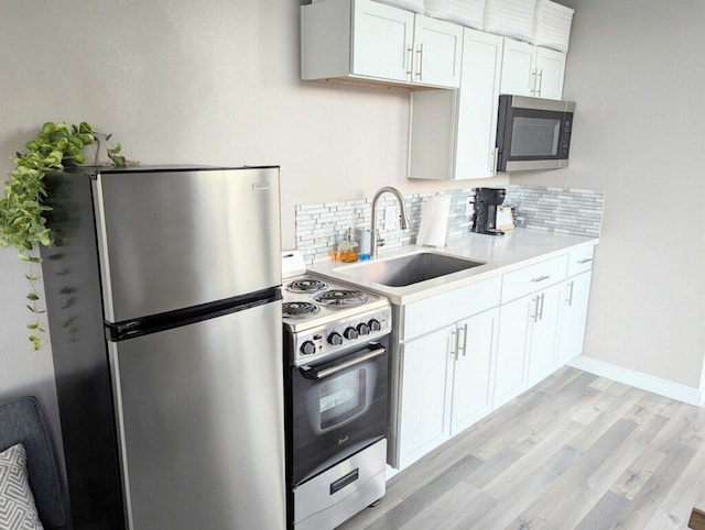 kitchen featuring white cabinetry, appliances with stainless steel finishes, and decorative backsplash