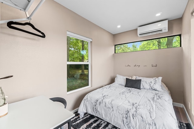 bedroom featuring hardwood / wood-style flooring and an AC wall unit