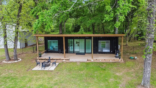 rear view of house with a wooden deck and a yard