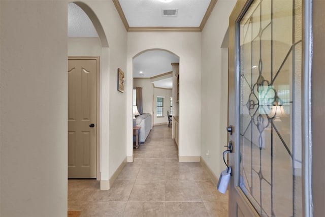 tiled entrance foyer with a textured ceiling and ornamental molding