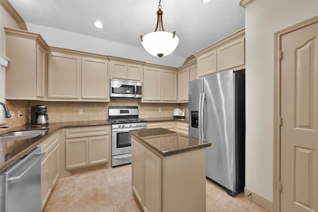 kitchen with a center island, sink, hanging light fixtures, dark stone countertops, and stainless steel appliances